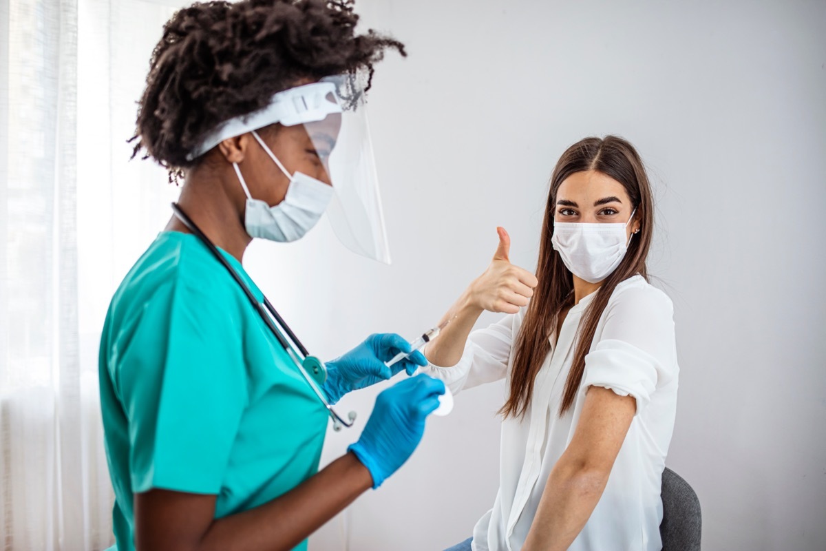 Happy vaccinated woman gesturing thumbs up.