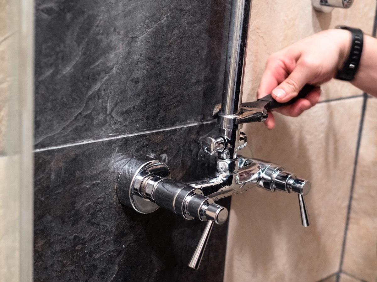 Person Fixing Shower Pipes