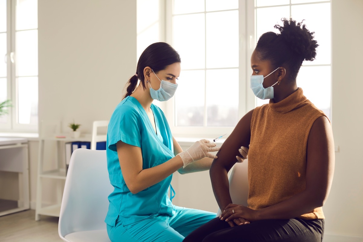 woman gets covid vaccine, sitting in chair