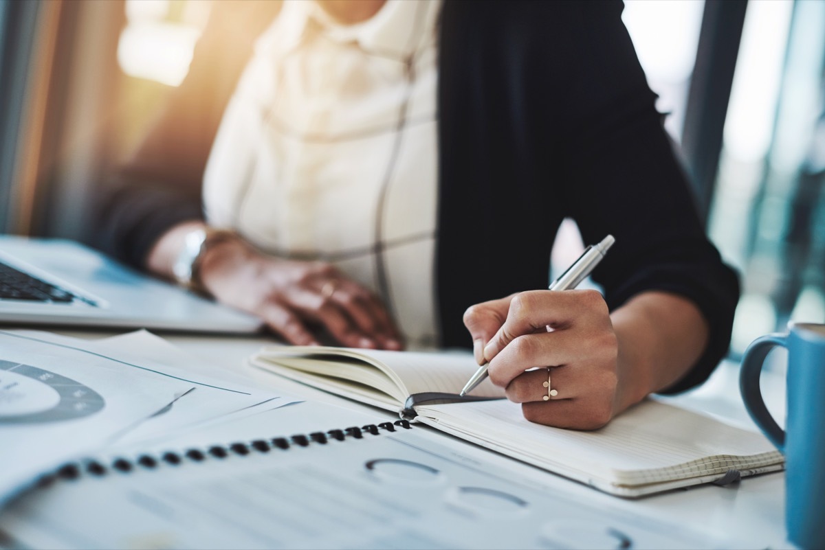 Woman writing down her goals in a notebook