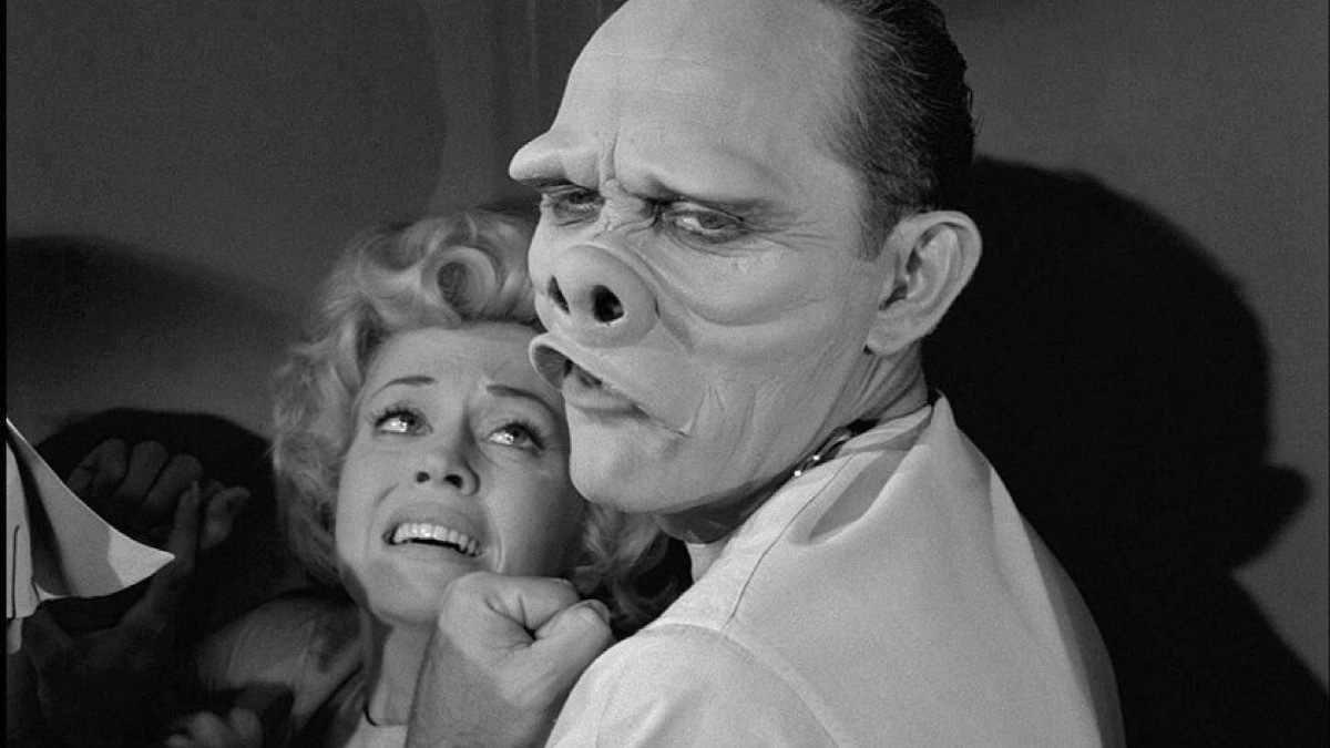 frightened woman cowering from monstrous deformed face on the twilight zone