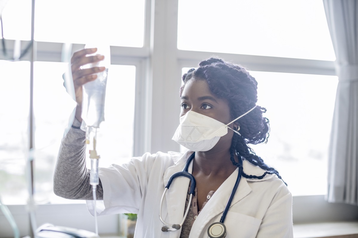 Female doctor working in hospital, holding intravenous drip, accuracy, protection, care