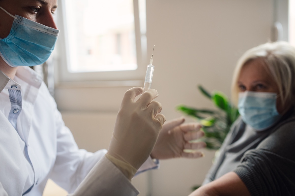 A doctor is checking the vaccine dose before she gives it to her patient due to the coronavirus pandemic.