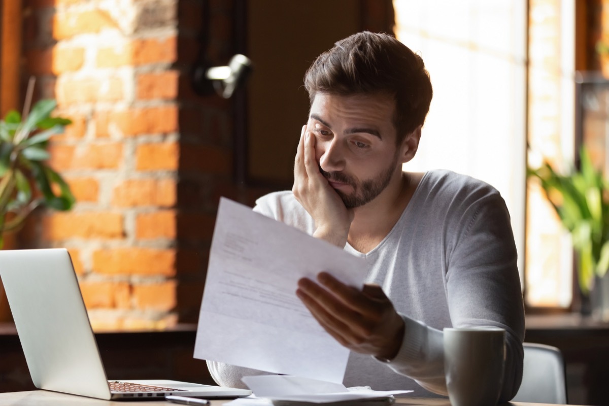 man upset looking at bills