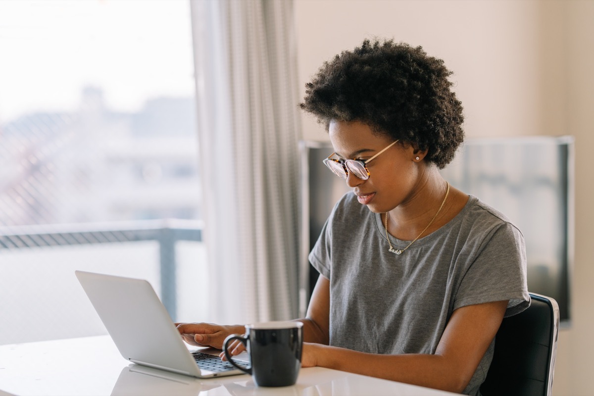 woman is using a laptop in the living room at home, body skip breakfast because she is too busy .