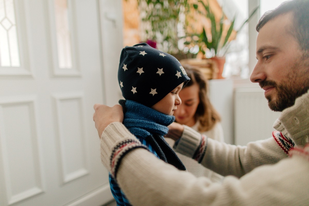 parents putting kid in a sweater