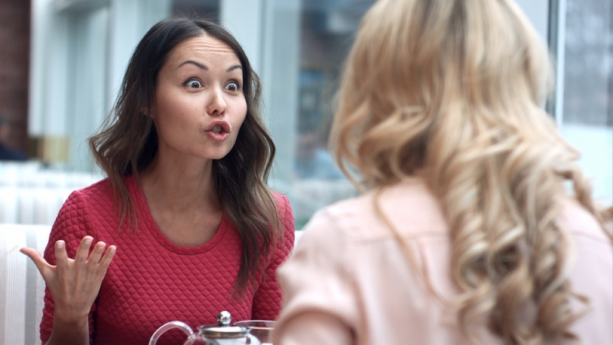 women arguing outdoors at table