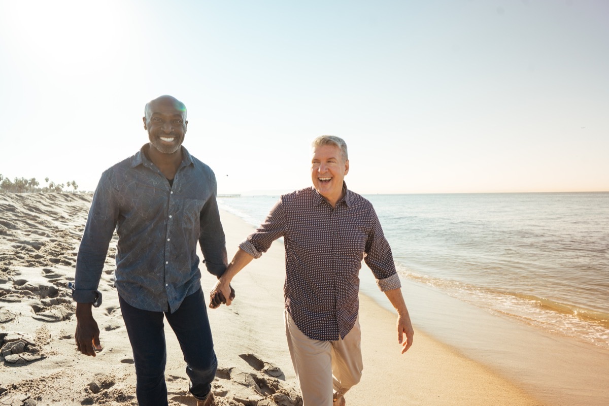 old couple walking on beach together