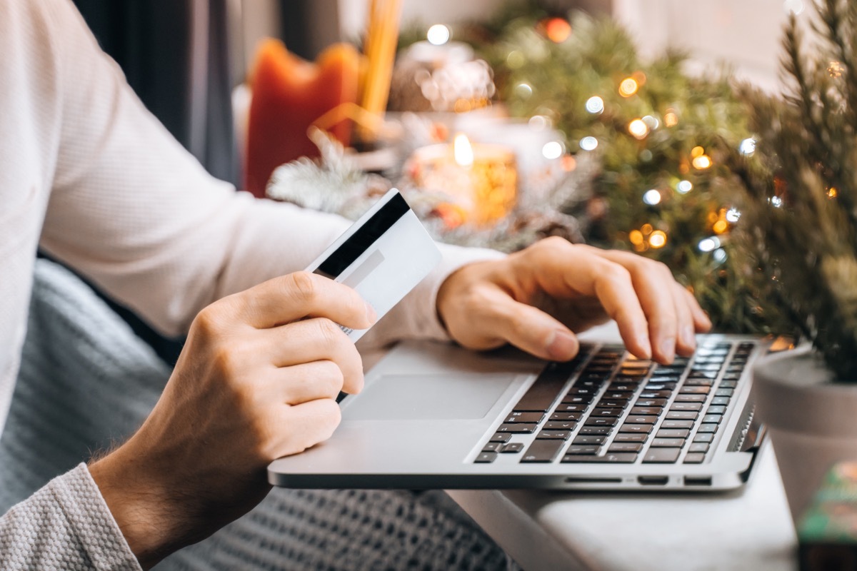 man shopping for holiday gifts online using card