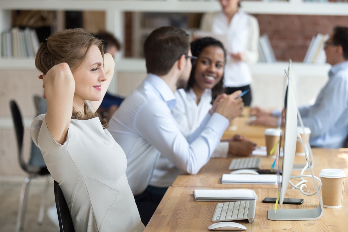 Woman smiling at her desk at work mental health awareness