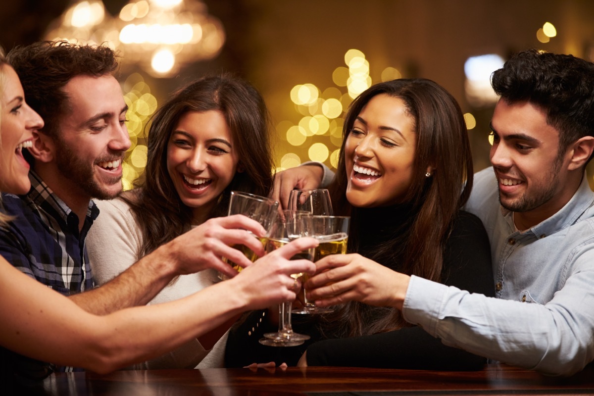 Friends drink and laugh at bar