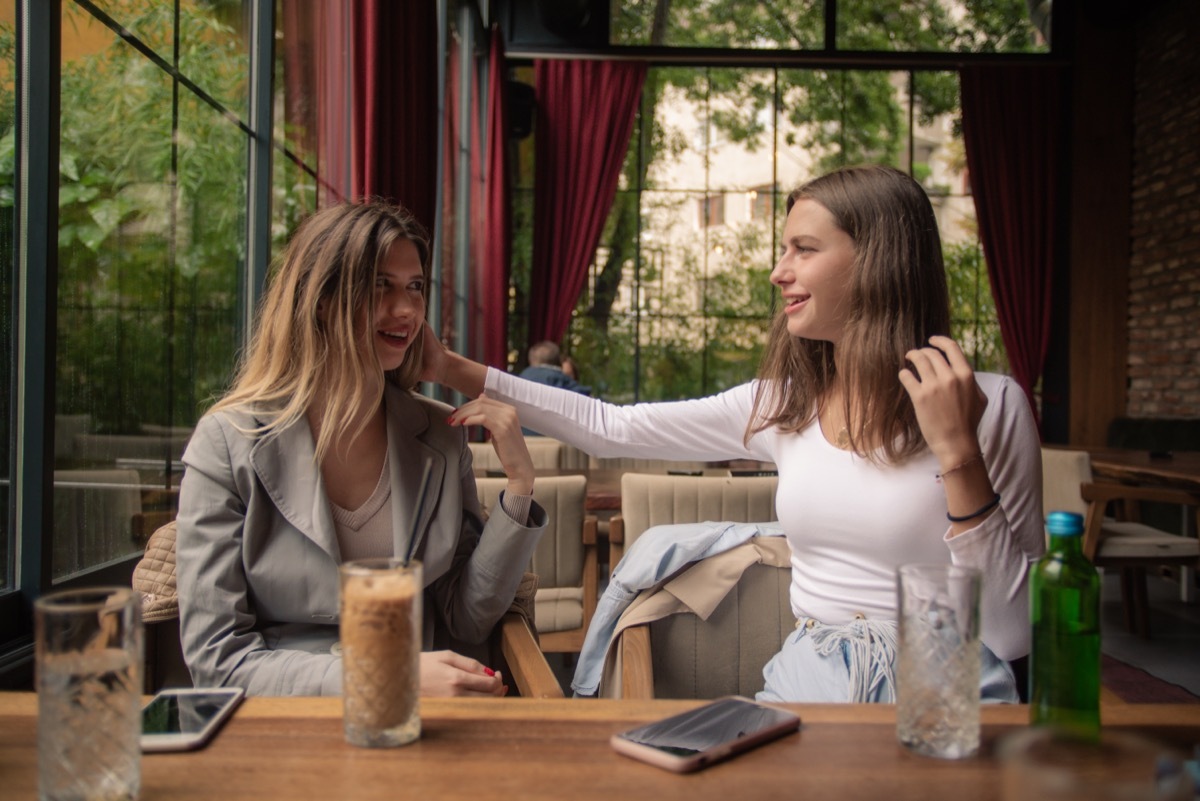 woman giving her friend a little compliment about her hair