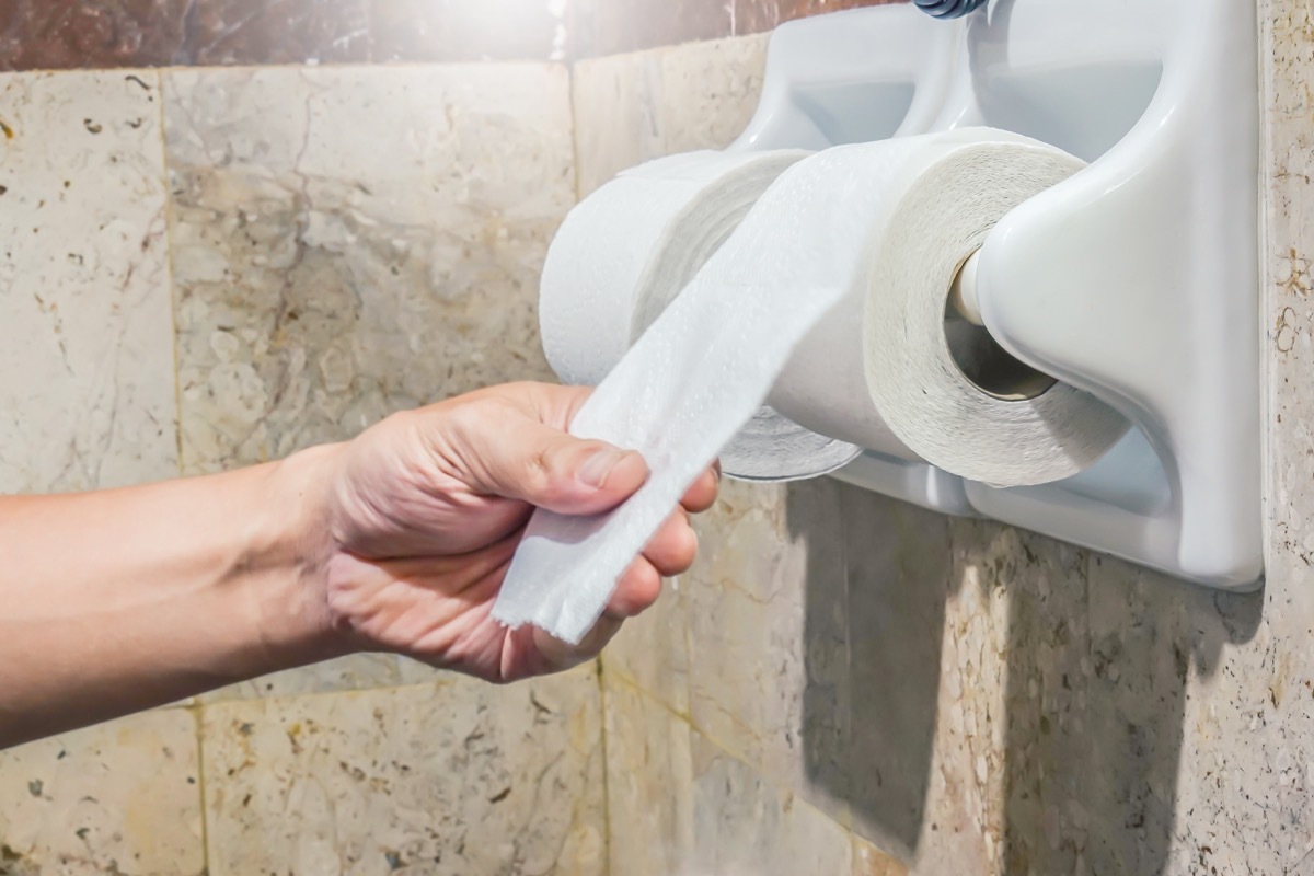 hand reaching for toilet paper roll