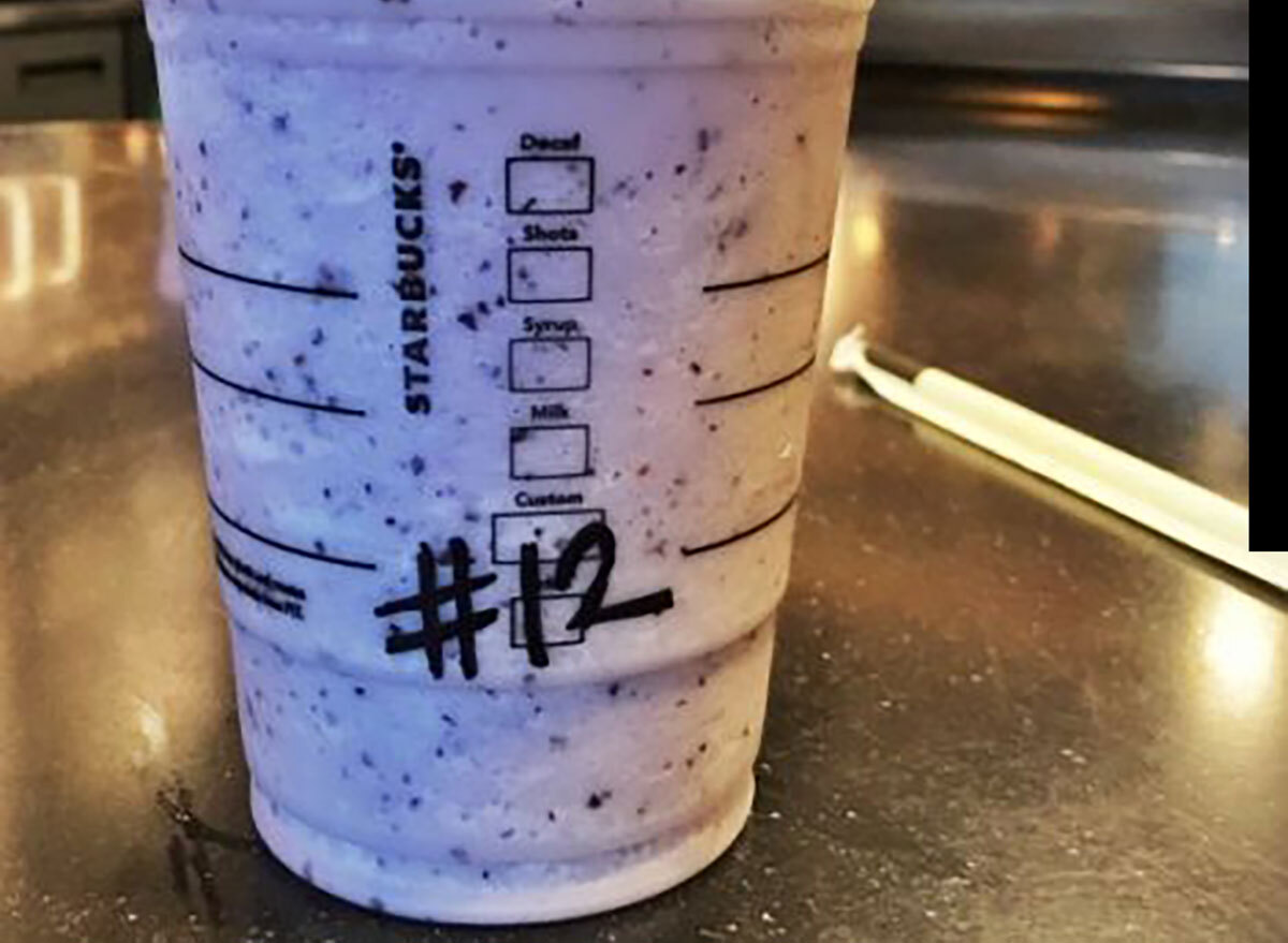 starbucks seahawks blueberry frappuccino with number 12 on table next to wrapped straw