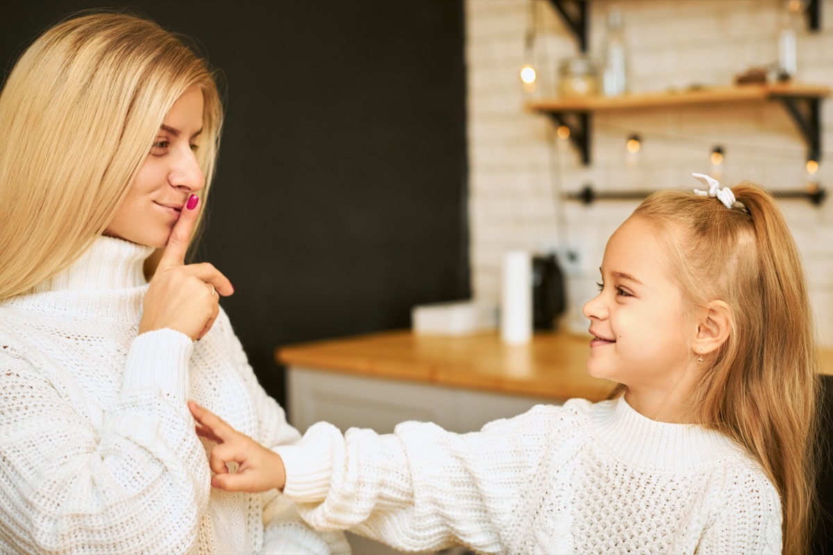 white blonde woman shushing young daughter