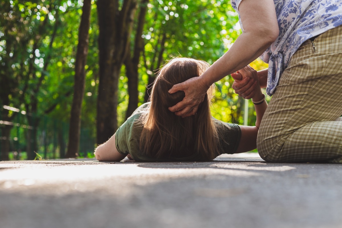 Woman being helped after she fainted outside