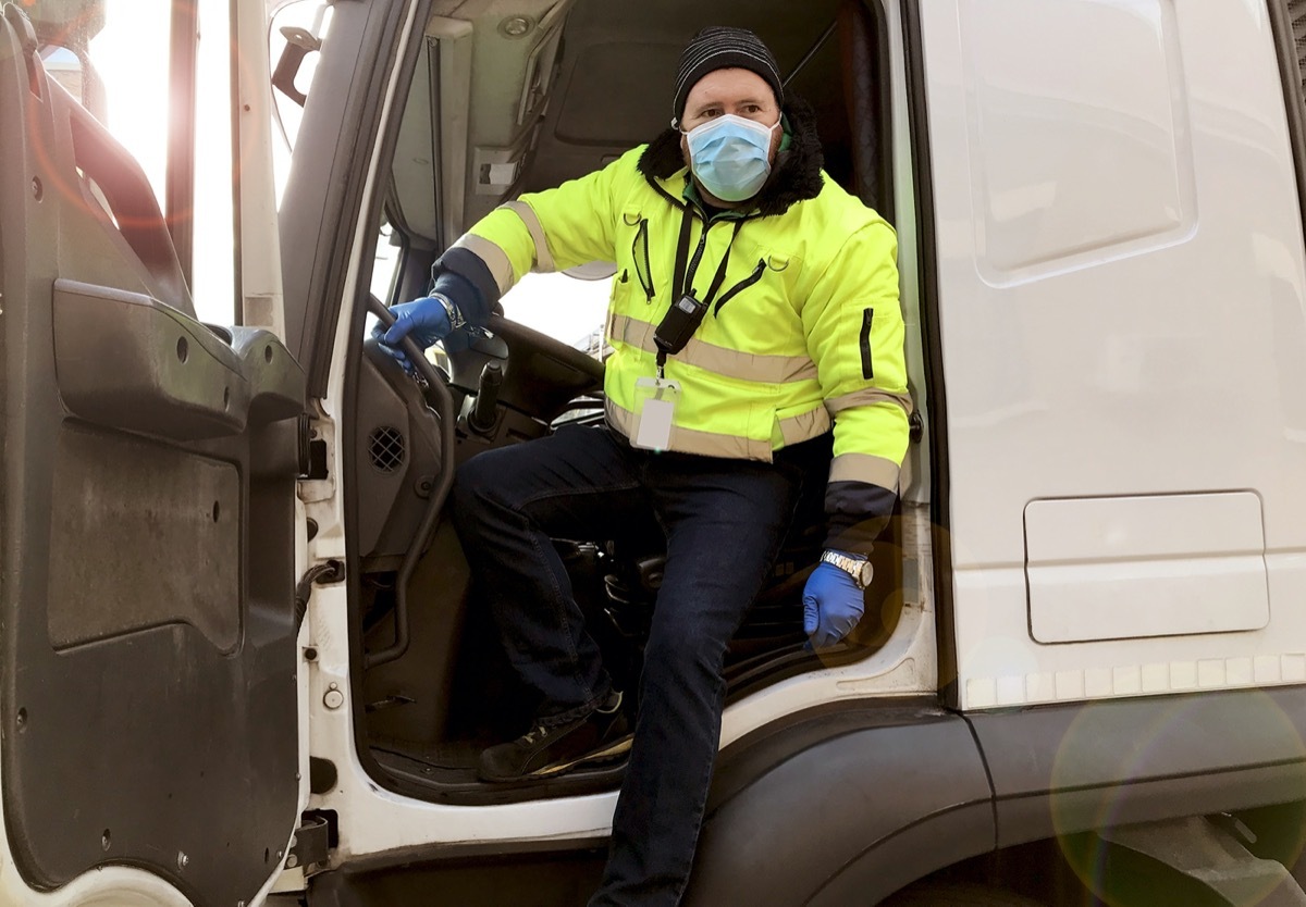 Man driving truck while wearing mask and gloves