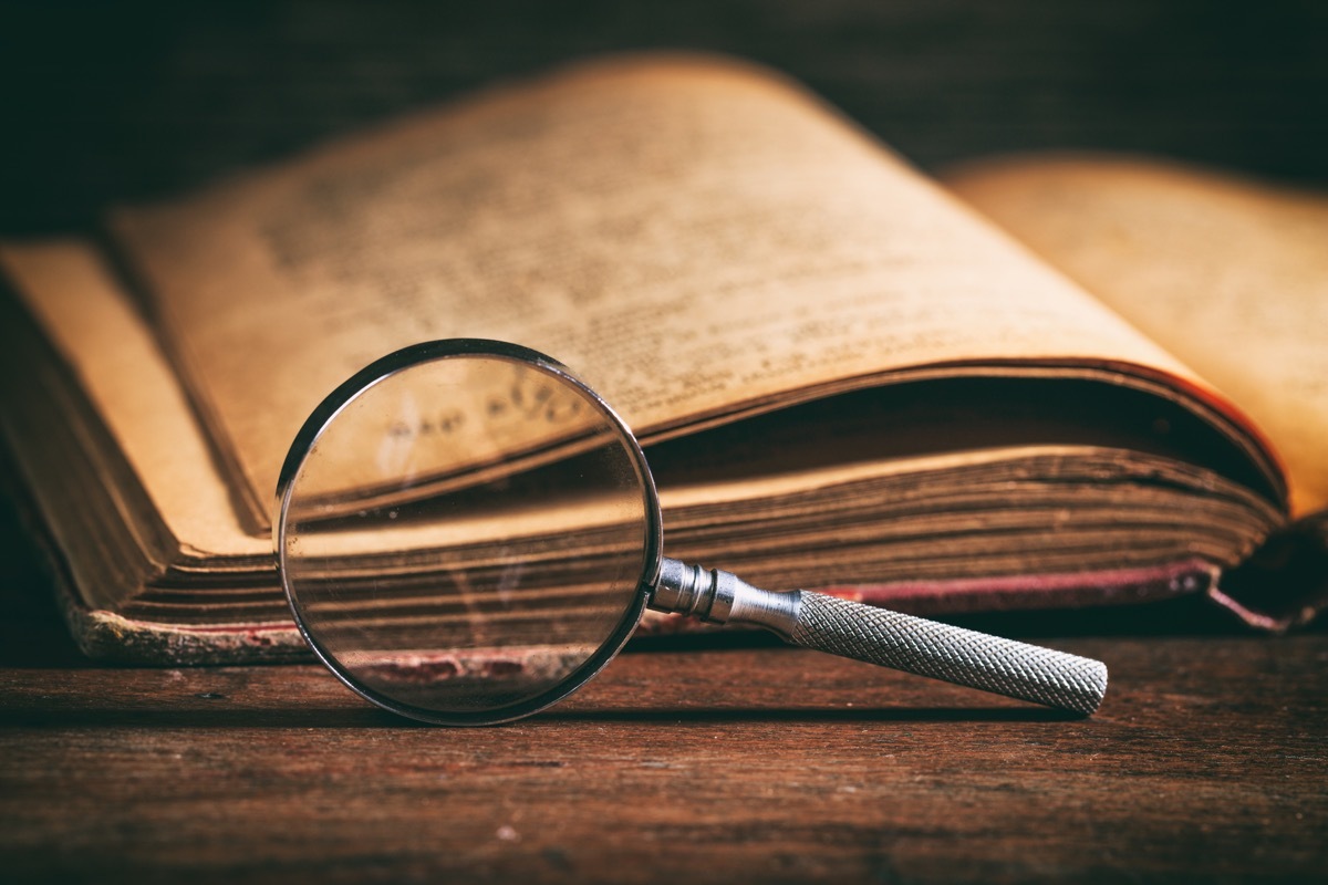 a dusty dictionary and a magnifying glass