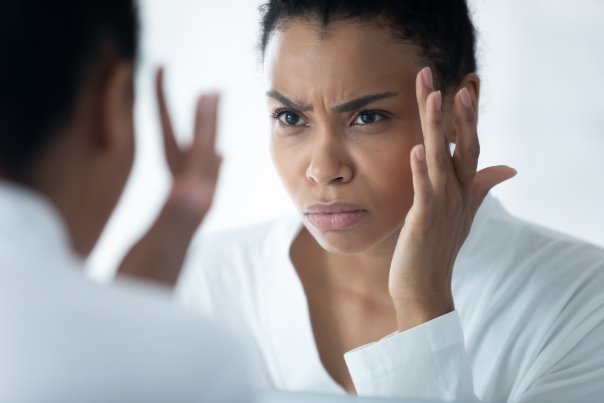 oman wear white bathrobe looking in mirror see first mimic wrinkles feels stressed, face skin lose elasticity changes after 30s, aging process, need cosmetology facial treatment concept