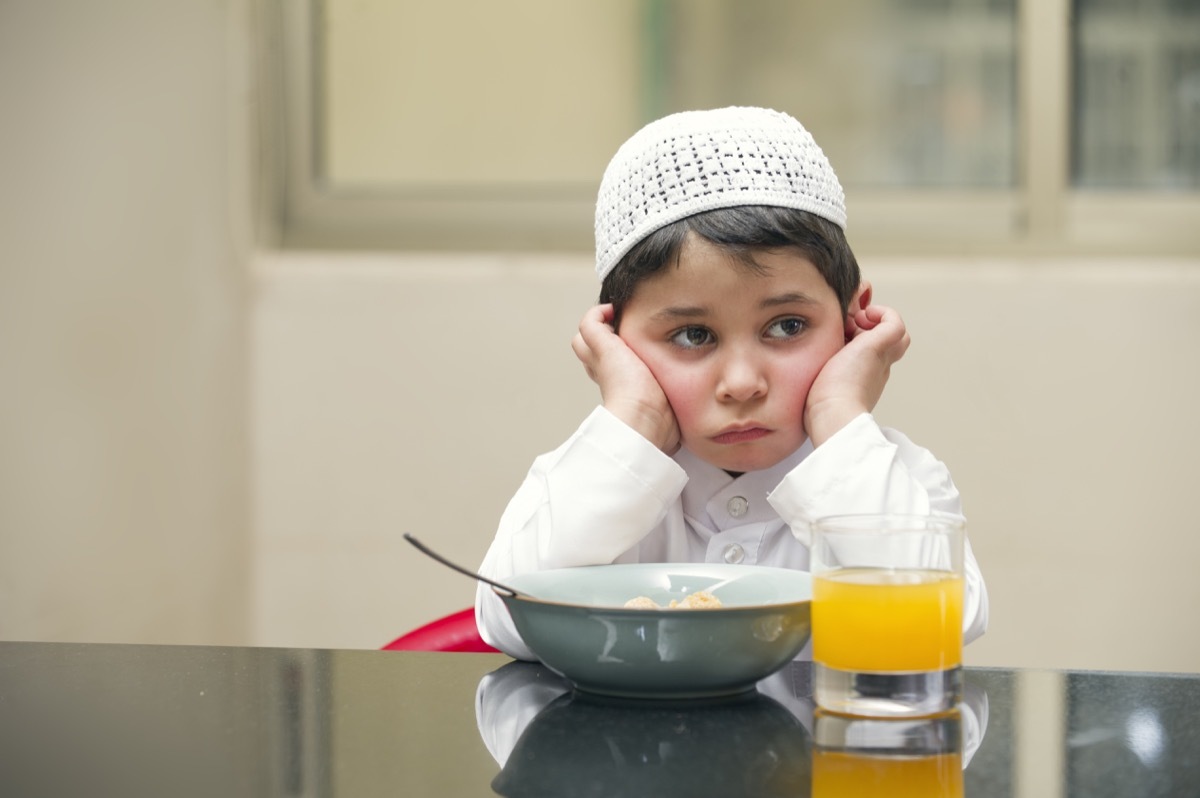 unhappy child eating meal old-fashioned manners