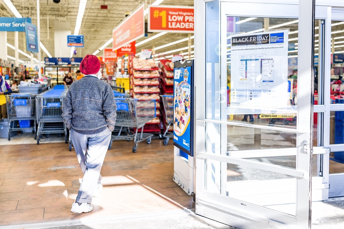 Burke, USA - November 24, 2017: Black Friday sign in Walmart store entrance with map after Thanksgiving shopping consumerism in Virginia with sikh man walking inside