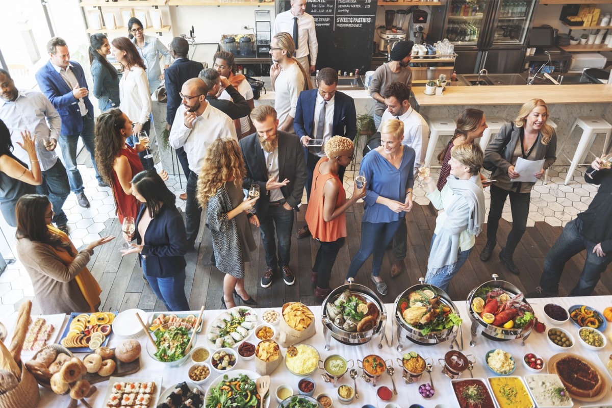 group of people standing near buffet at party