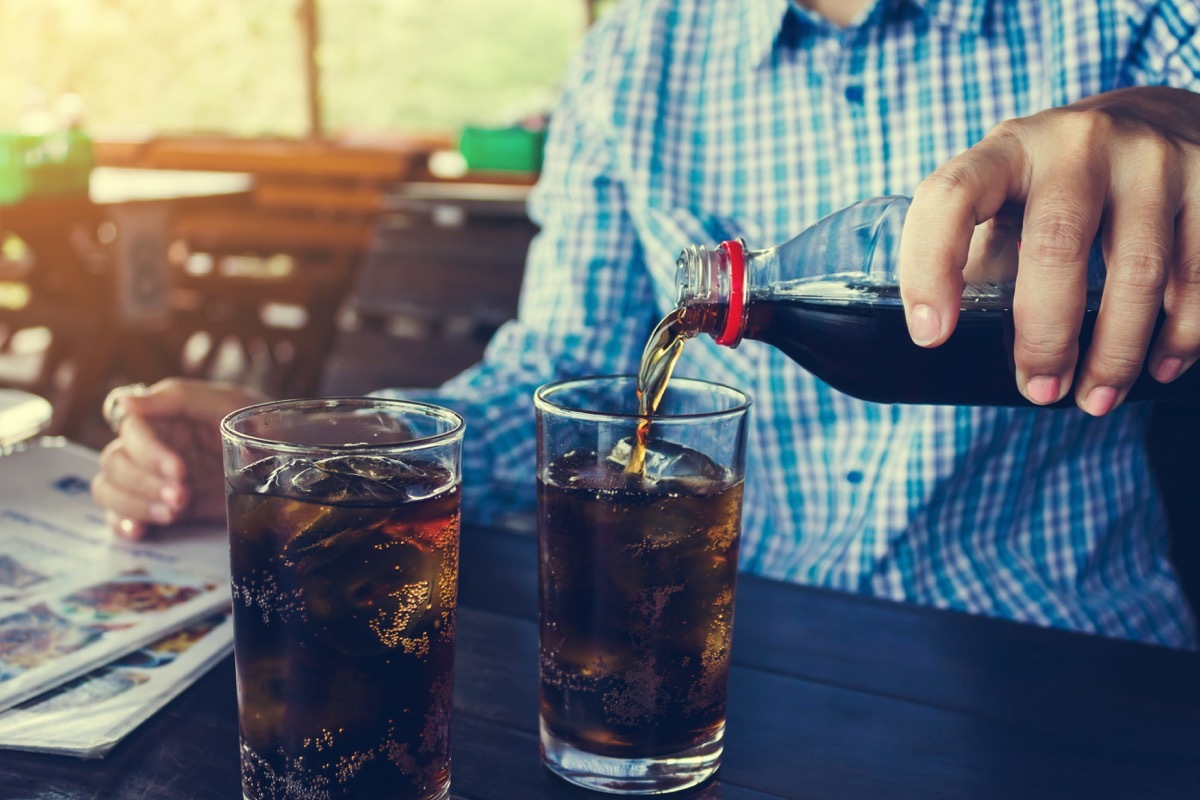 Man pouring soda into glass