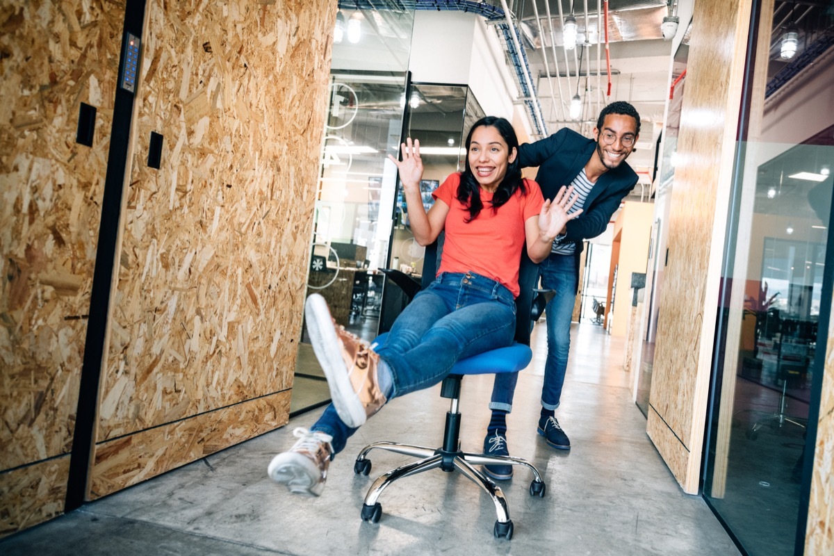 Co-workers doing an office chair race