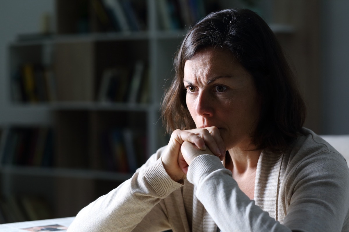 Woman sitting with her chin in her hands looking upset