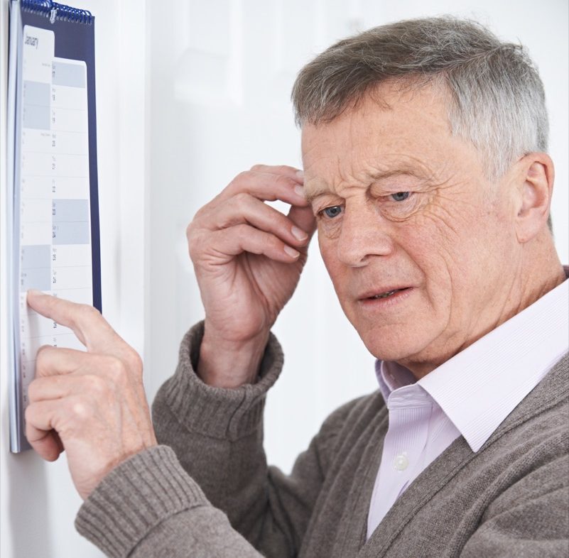 Senior man looking at a calendar confused