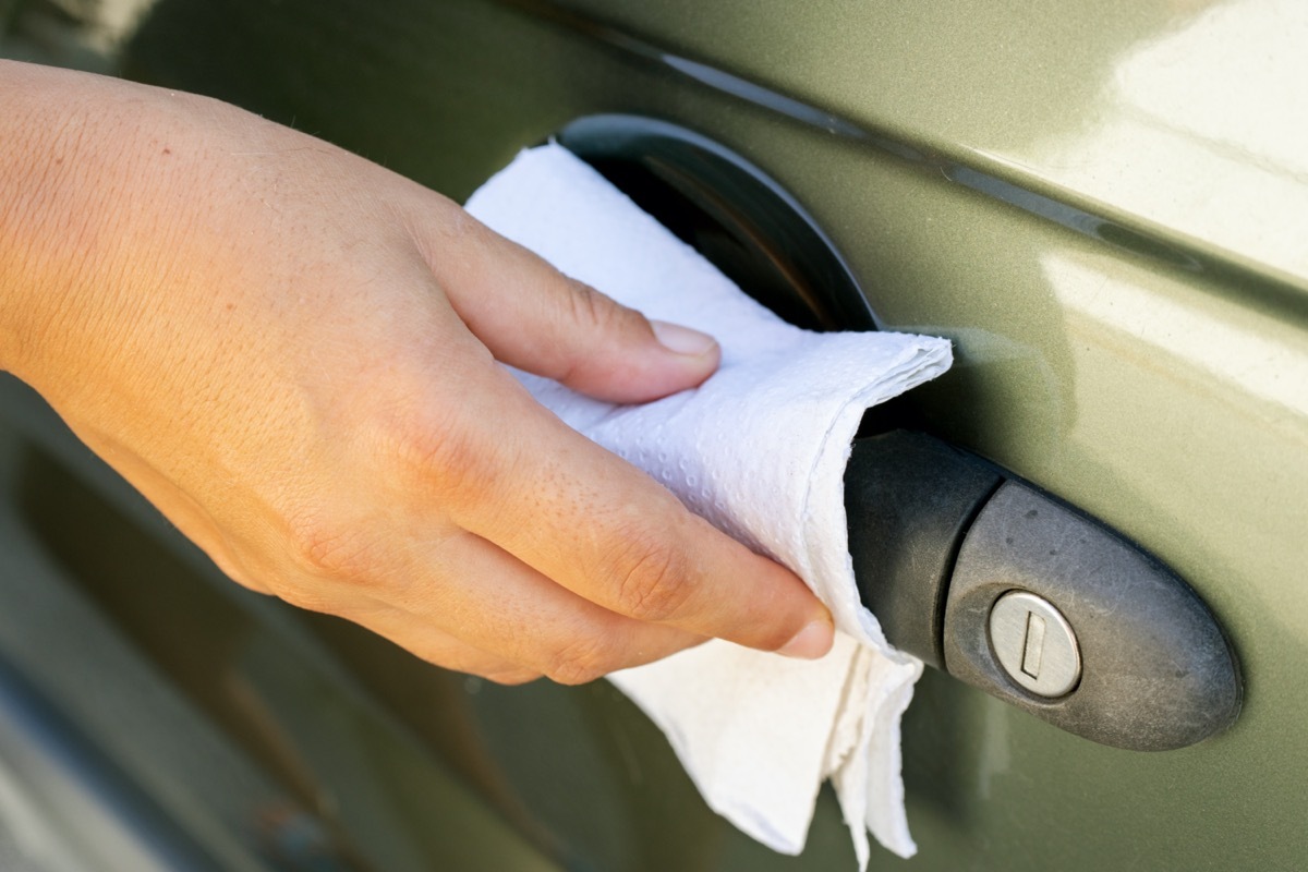 cleaning car handle with paper towel and disifectant