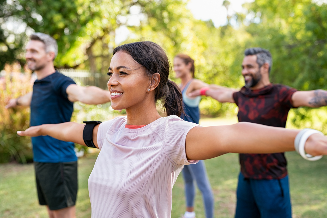 Group of people stretching outdoors.