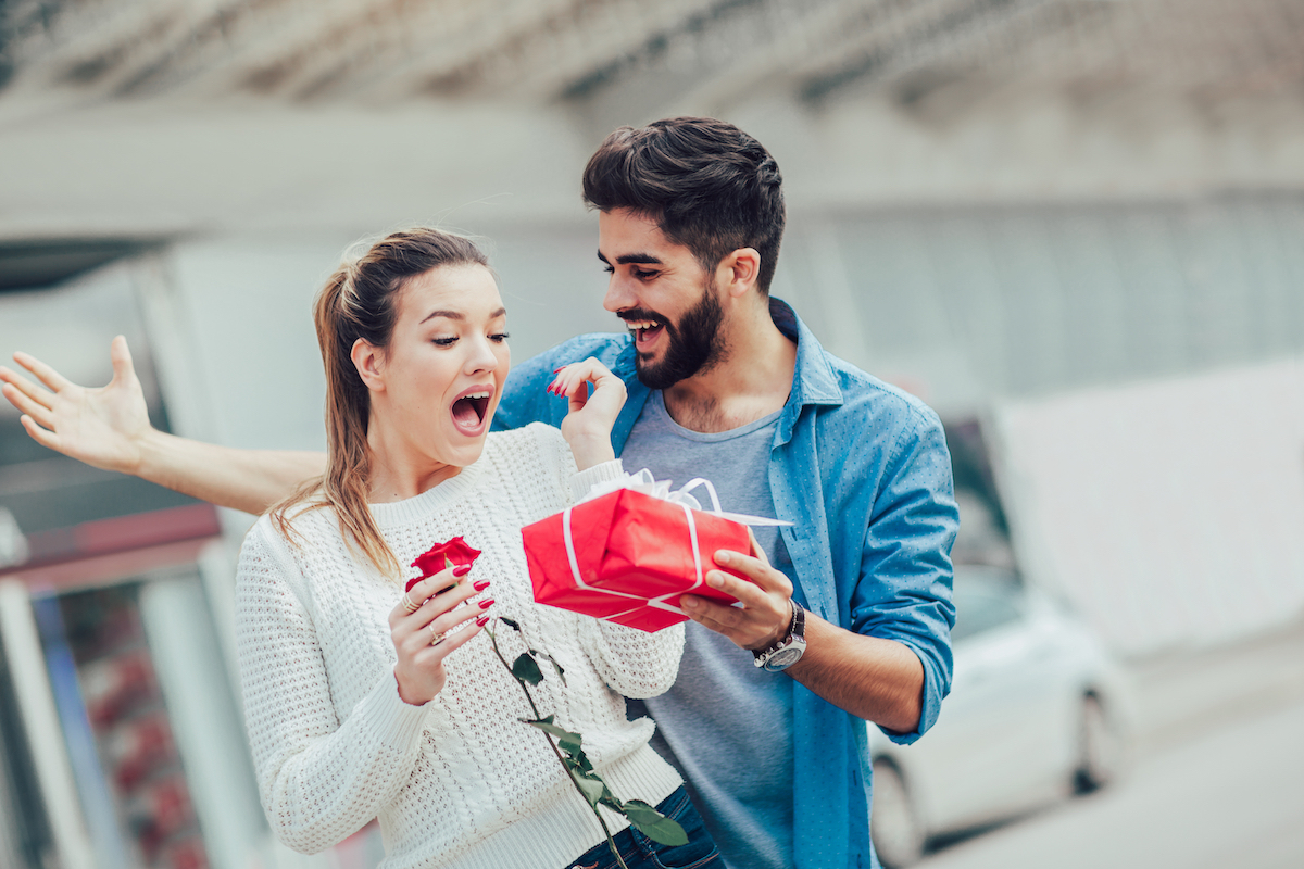 Romantic Man giving flower and gift box to woman for valentines day