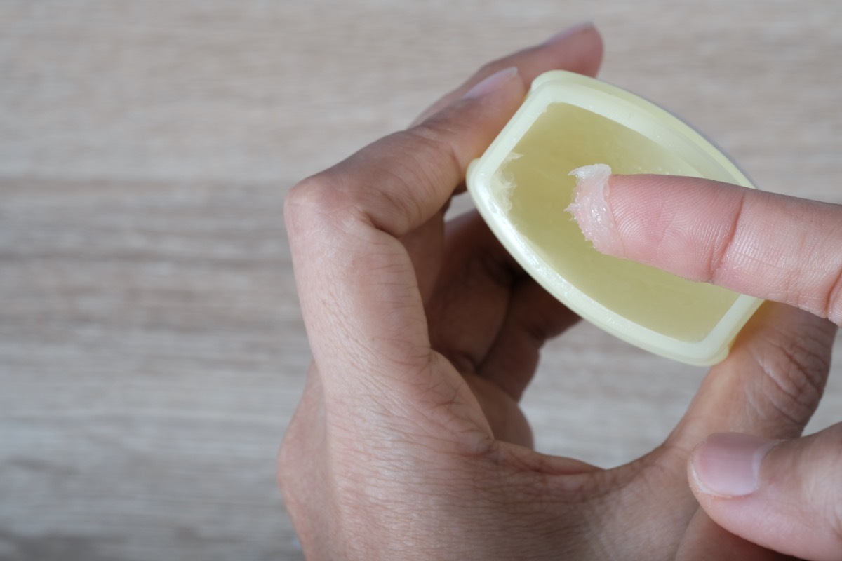 A finger dipped in petroleum jelly jar