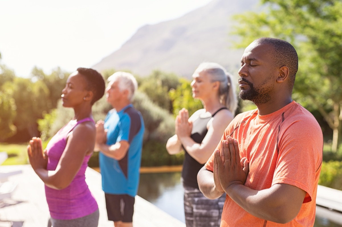 four senior people meditating