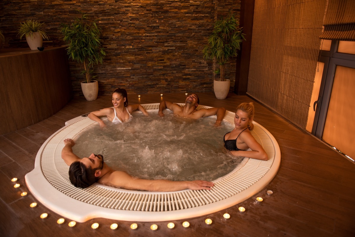 group of young friends using hot tub or jacuzzi