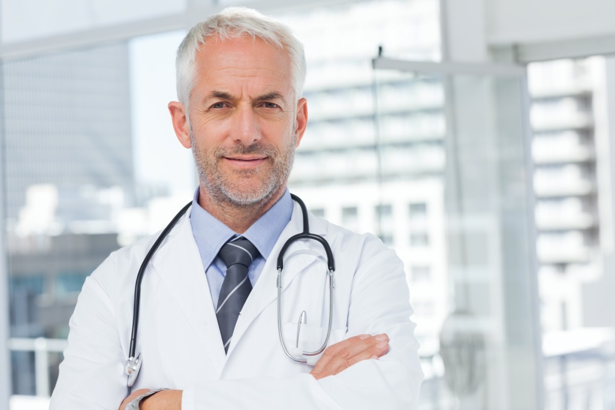 Doctor with stethoscope around his neck looking at the camera