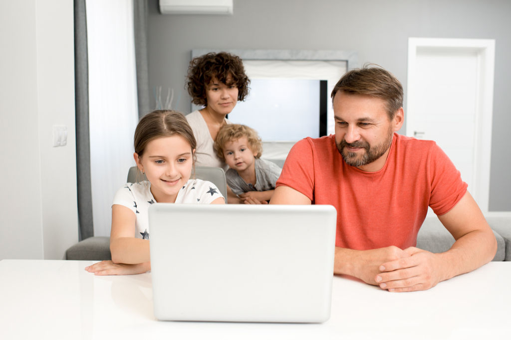 Man, woman, and two small children looking at laptop