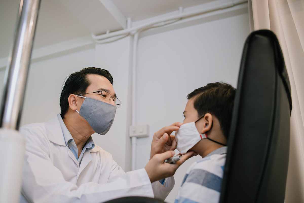 Ophthalmologist checking patient's eye while Covid spreads