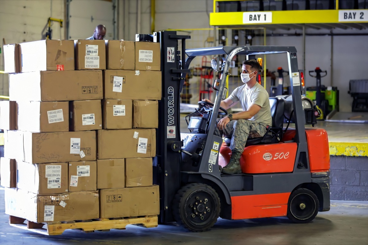 Forklift / lift truck driver operating forklift / lift truck and transporting goods / cargo / logistic from at Amazon warehouse or ship dock yard in crona virus in Berlin, Germany on 6th June 2020