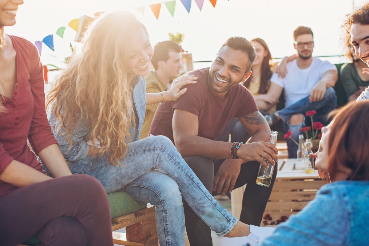 group of young people chatting and laughing on a party.