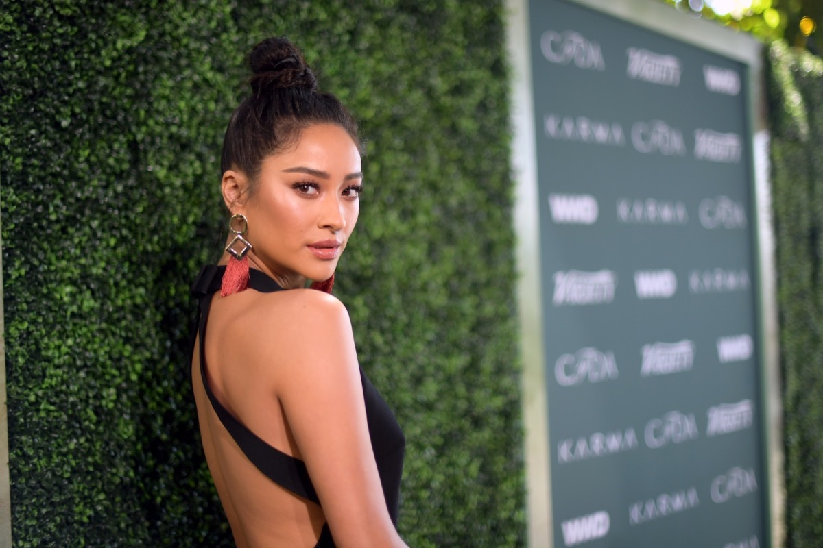 shay mitchell in black dress with pink earrings