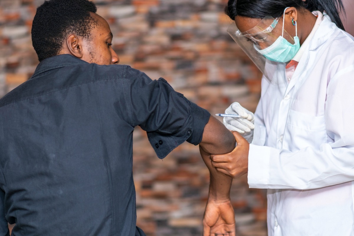 young man in gray shirt getting covid vaccine