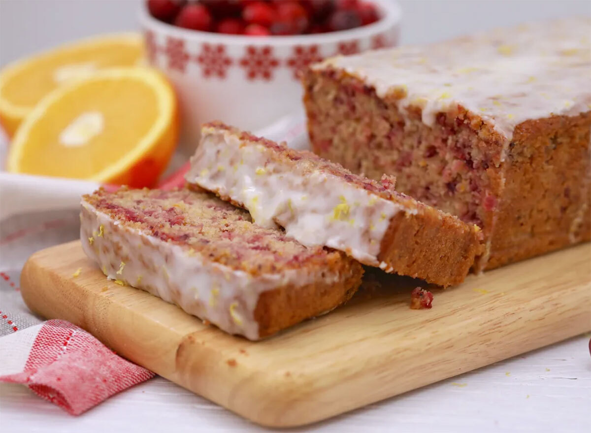 cranberry orange cake slices on cutting board with lemon icing