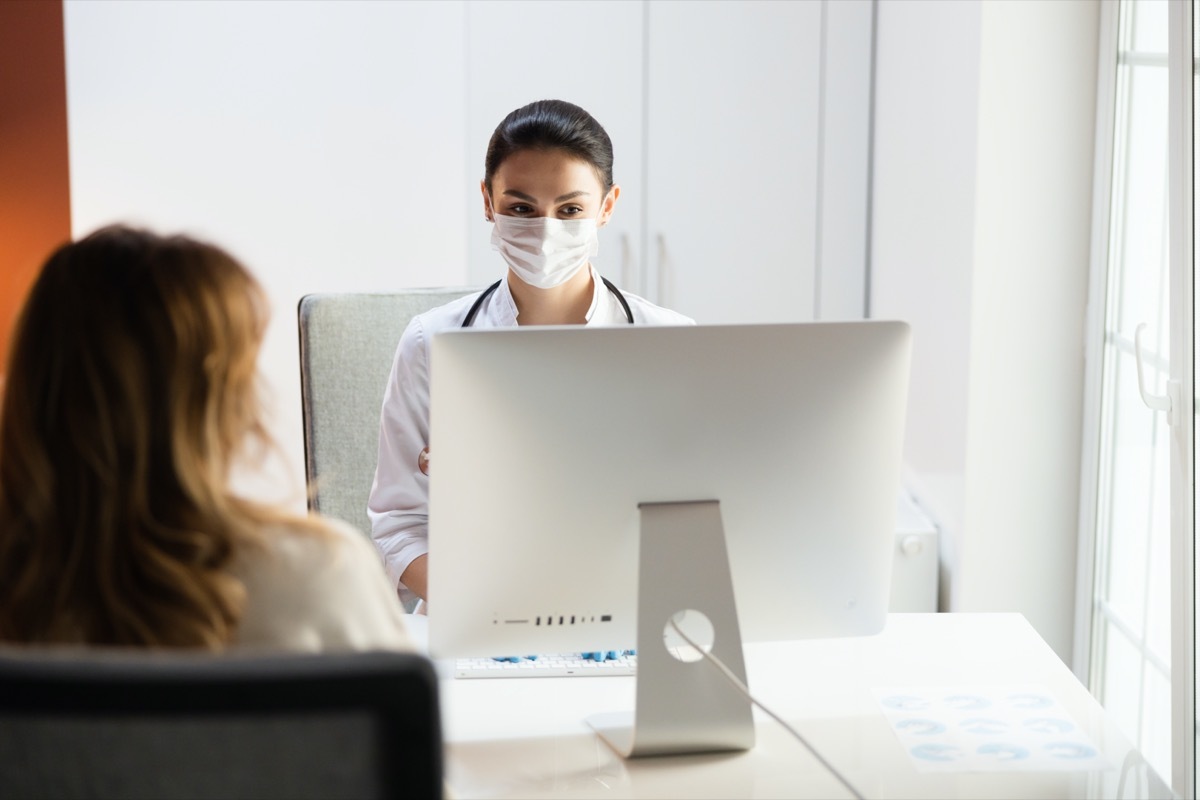 Patient looking at pediatrician in medical mask in clinic