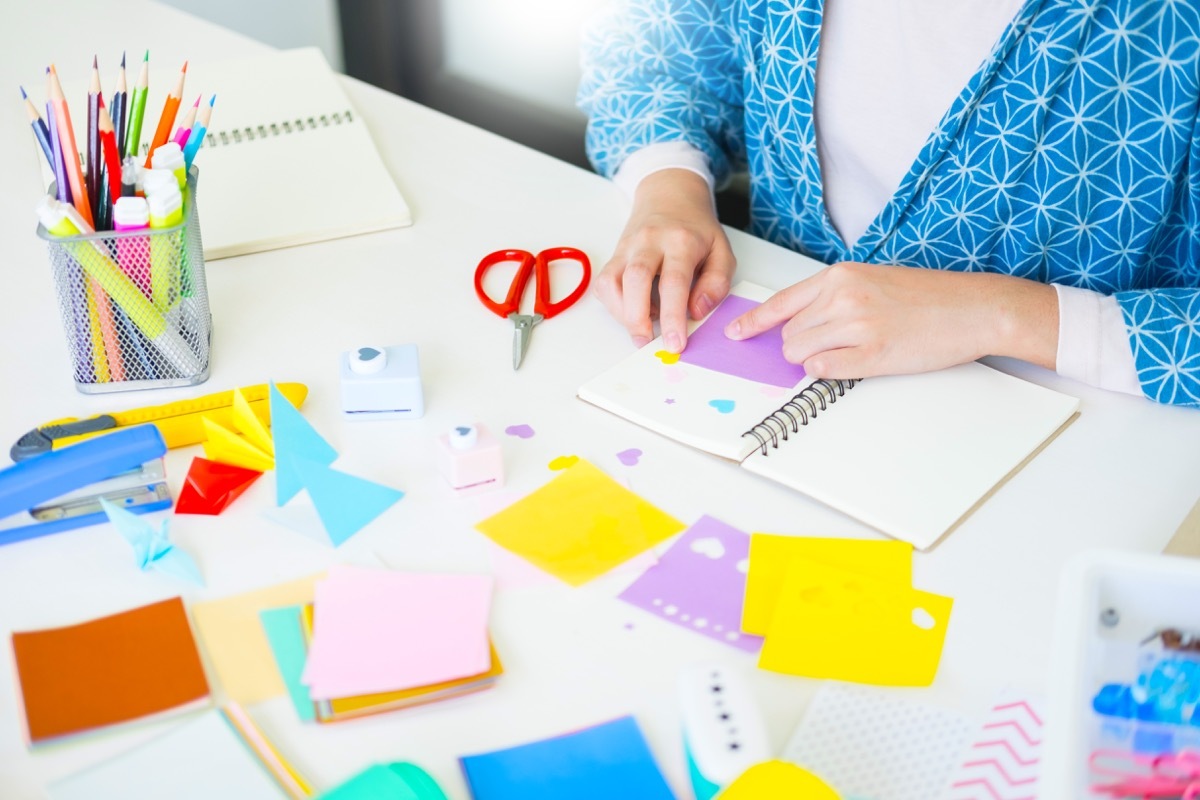 Woman doing a DIY crafting project on some sort of book