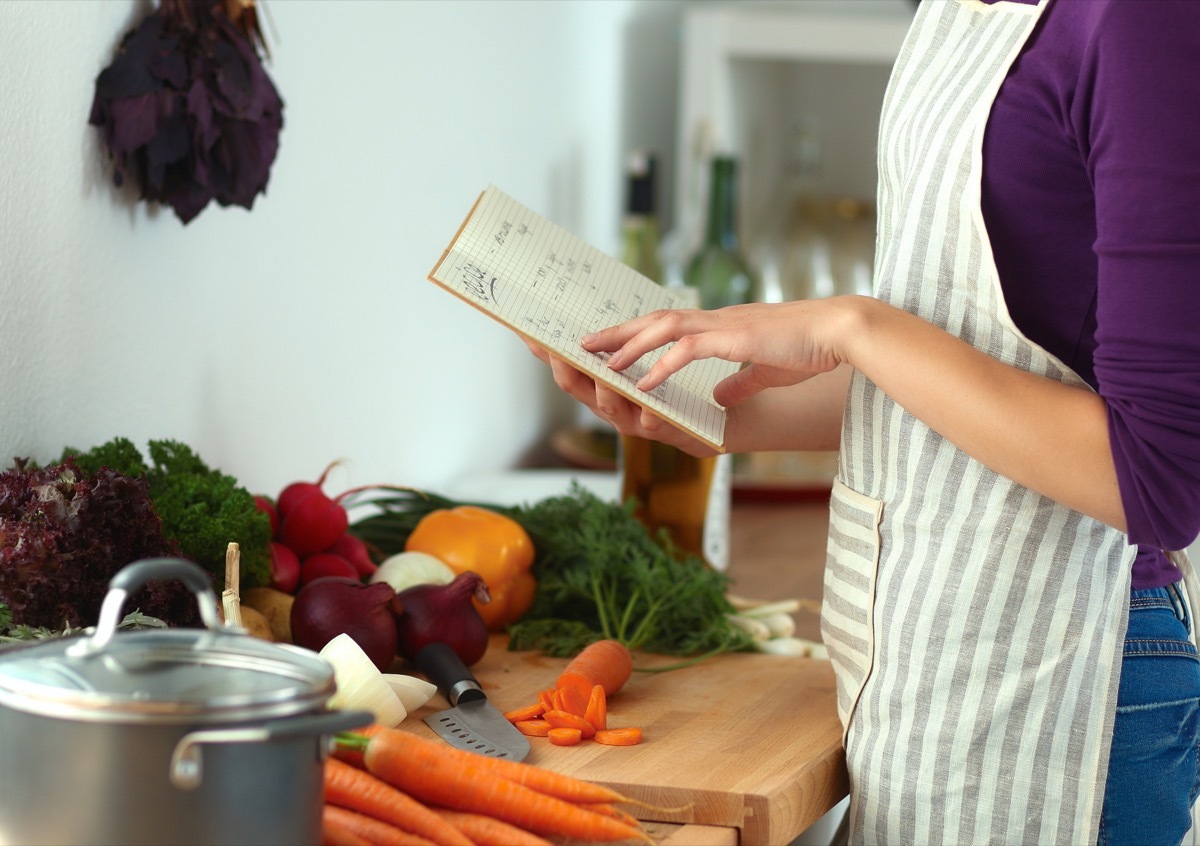 Woman Using a Cookbook in the Kitchen {Home Organization Tips}