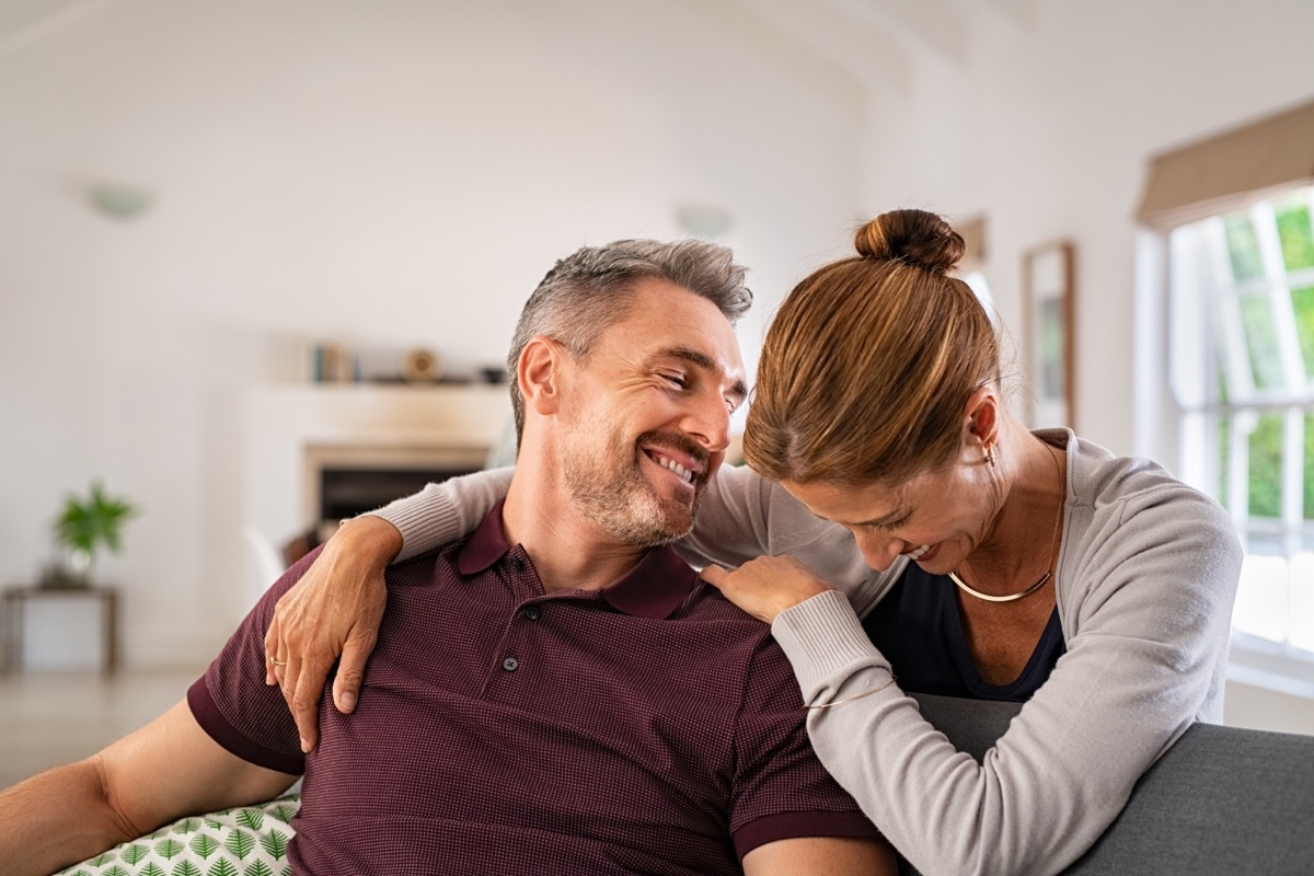 older couple sitting on a couch laughing