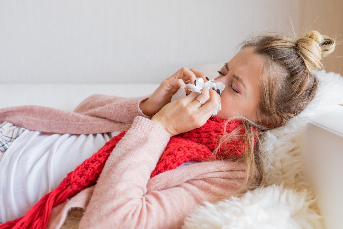 Sick woman with tissue and running nose