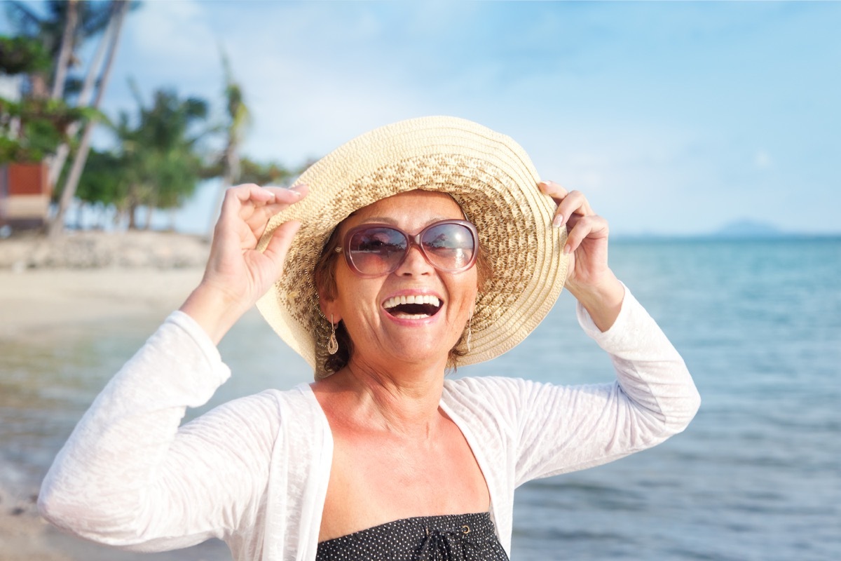 Happy mature woman of 50 60 years on the beach